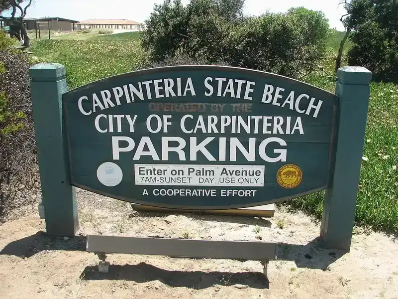 Carpinteria State Beach parking sign in the shade of coastal trees